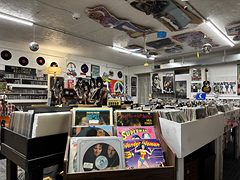 Bins of vinyl records and a wall of album covers in the record section