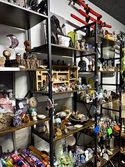 Black metal shelves of crystals, figurines, candles and small collectibles
