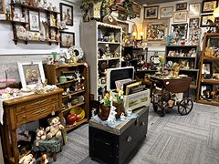 Vintage furniture with a wooden dresser, teddy bears, framed pictures and a tea cart