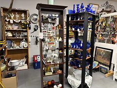 Wooden shelves and a tall case of cobalt blue glass, white enamelware and collectibles