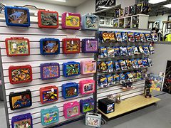 Wall of vintage lunch boxes beside racks of packaged toy cars