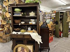 Dark wood hutch with green pottery and baskets next to an olive green metal locker