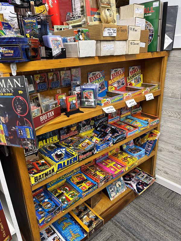 Wooden shelves of boxed vintage toys, including Batman and Alien figures