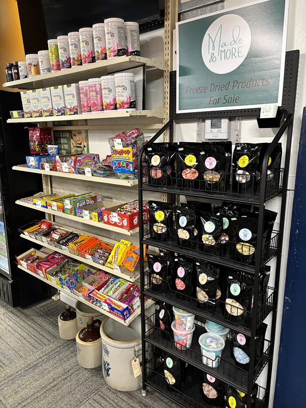 Shelves of candy and a black rack of bagged freeze-dried treats
