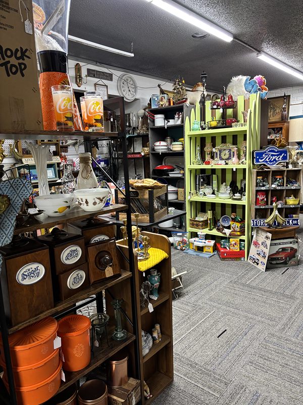 Aisle with orange canisters and kitchenware beside a lime green shelf of collectibles