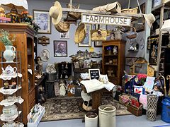 Farmhouse booth under a Farmhouse sign with hats, baskets, teapots and crocks