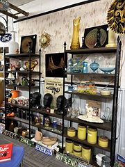 Black metal shelves of mid-century glassware and yellow canisters