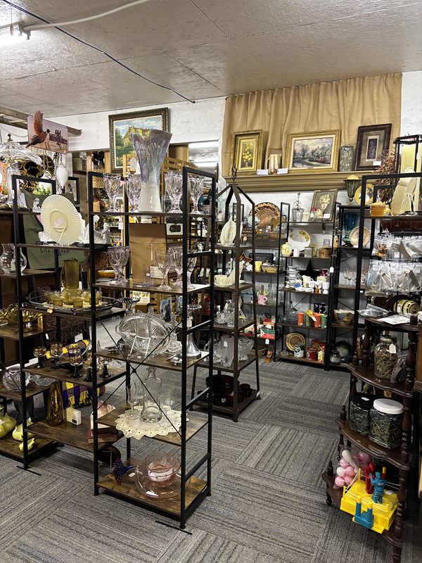 Tall metal shelves of glassware and home decor