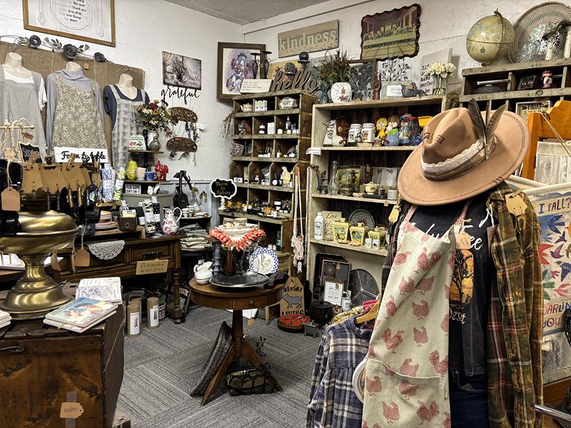 Booth with a cowboy hat and flannel on a mannequin, a round table and kitchen collectibles