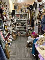 Narrow aisle of shelves with dolls, hats and collectibles