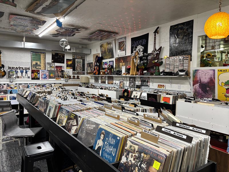 Long bins of vinyl records with music posters and memorabilia on the walls
